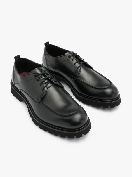 Schwarze Halbschuhe auf hellem Grund