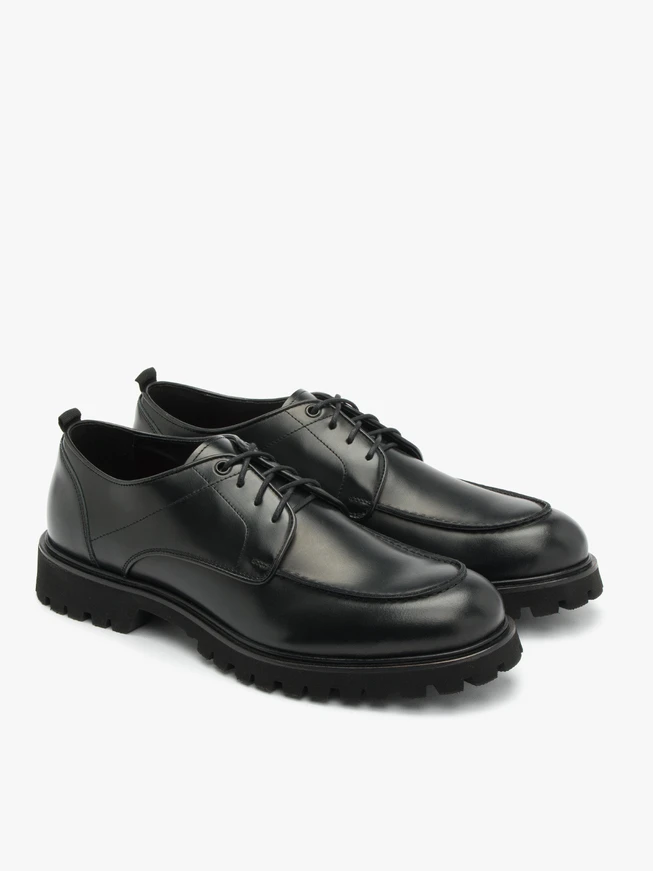 Schwarze Halbschuhe auf hellem Grund