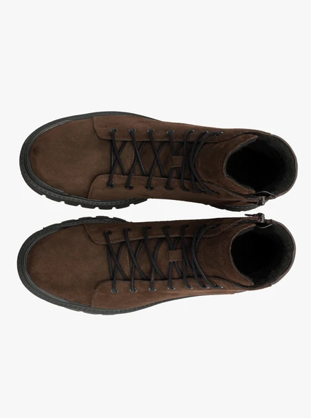 Dunkelbraune Stiefel auf leichtem Grund