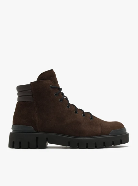 Dunkelbraune Stiefel auf leichtem Grund
