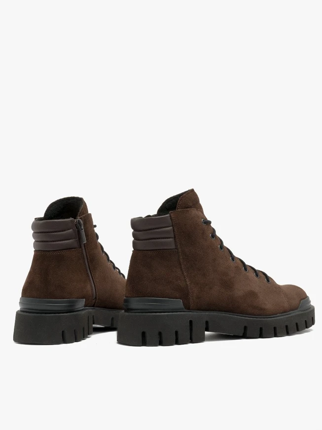 Dunkelbraune Stiefel auf leichtem Grund