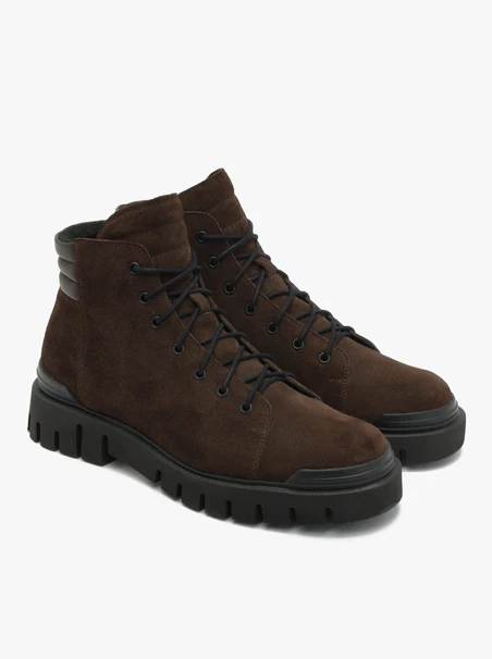 Dunkelbraune Stiefel auf leichtem Grund