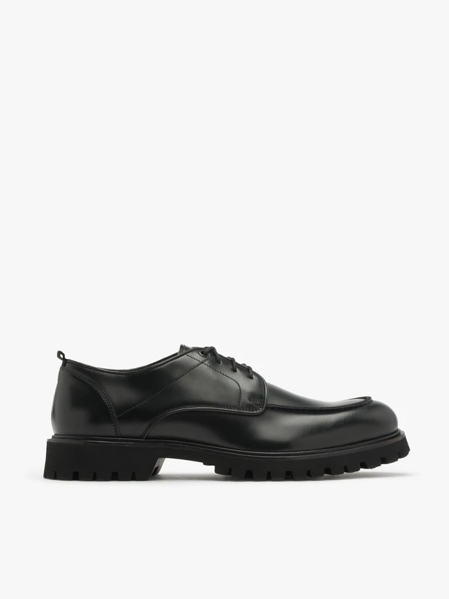 Schwarze Halbschuhe auf hellem Grund