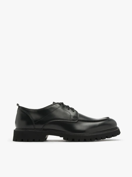 Schwarze Halbschuhe auf hellem Grund