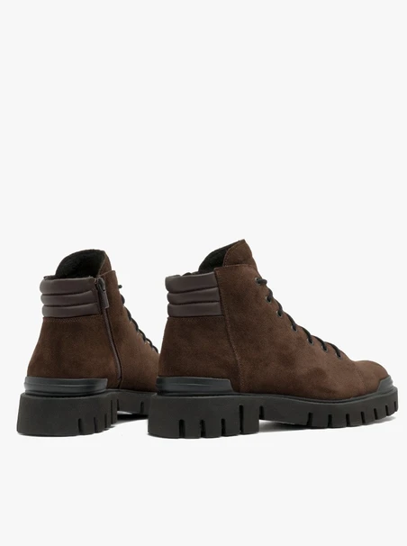 Dunkelbraune Stiefel auf leichtem Grund