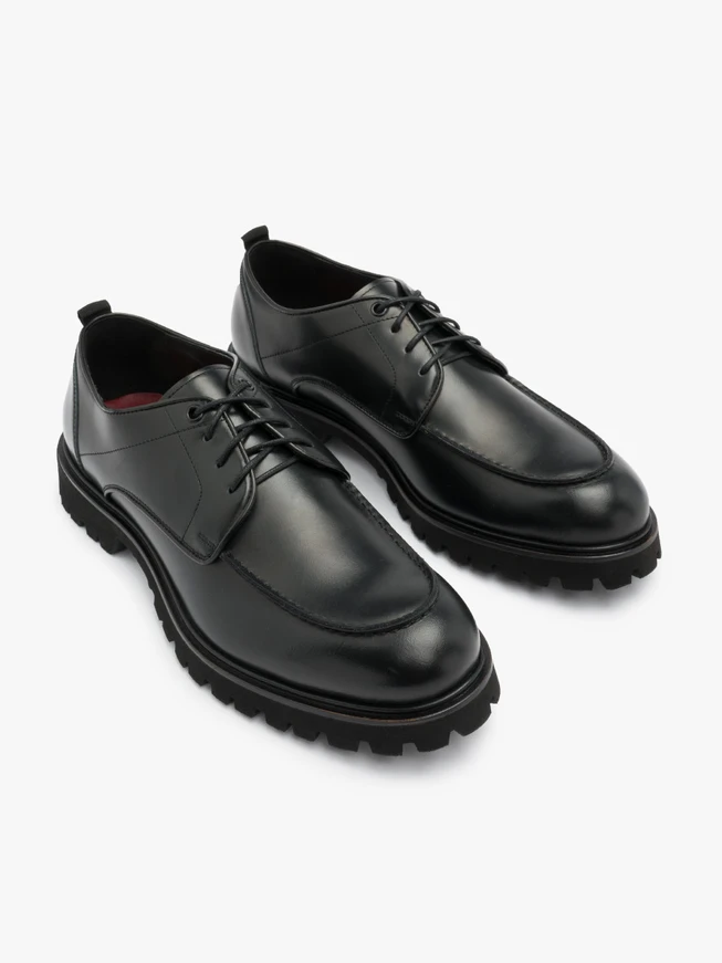 Schwarze Halbschuhe auf hellem Grund