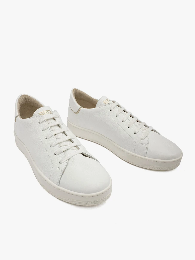 Weiße Sportschuhe mit goldenen Elementen