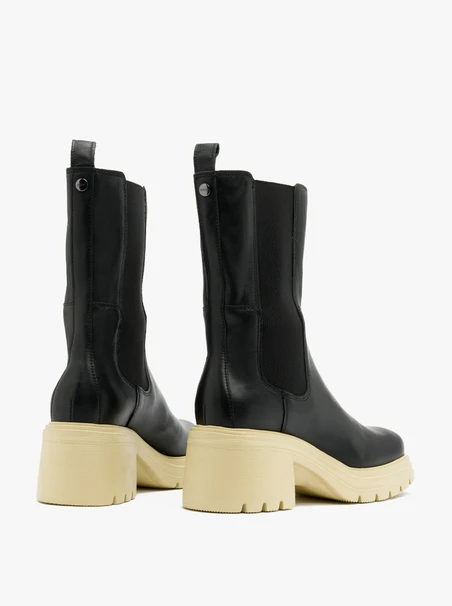 Schwarze Schlupfstiefel mit cremefarbener Sohle