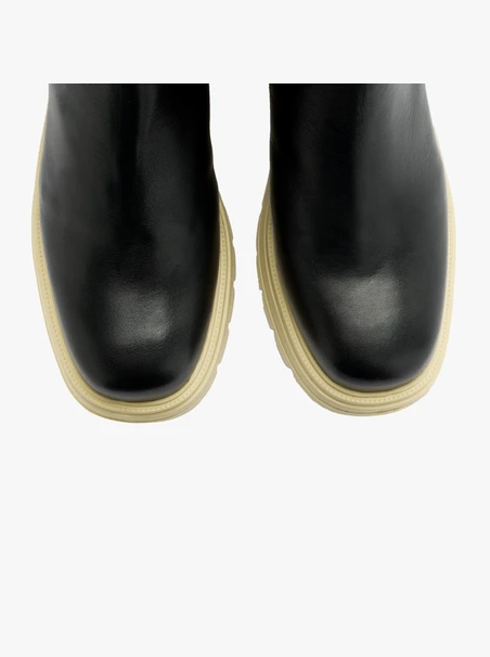 Schwarze Schlupfstiefel mit cremefarbener Sohle