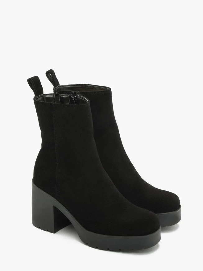 Schwarze Stiefel mit massivem Absatz, isoliert mit natürlichem Schafsfell
