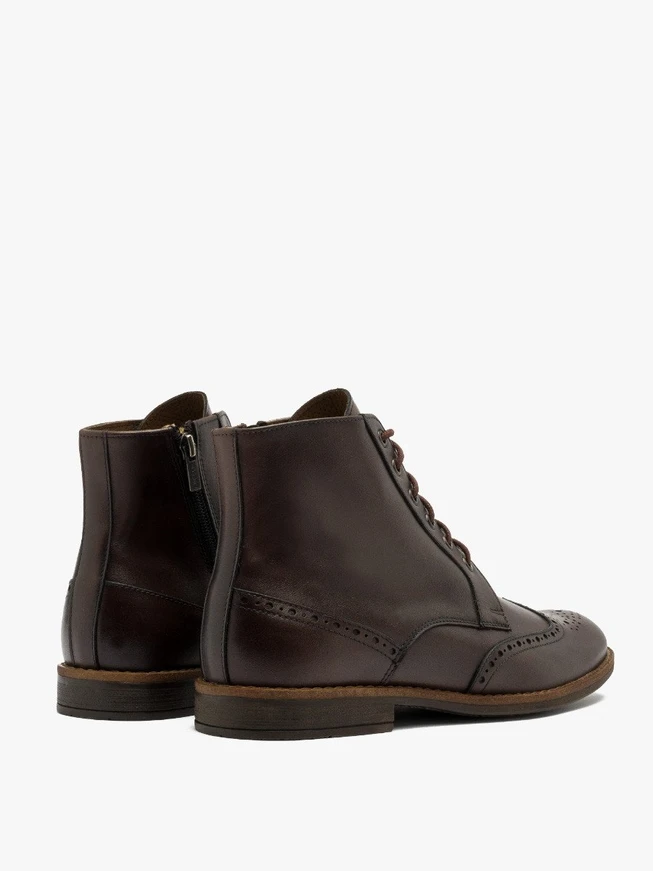 Braune Stiefel mit dekorativen Perforationen auf dem Schaft