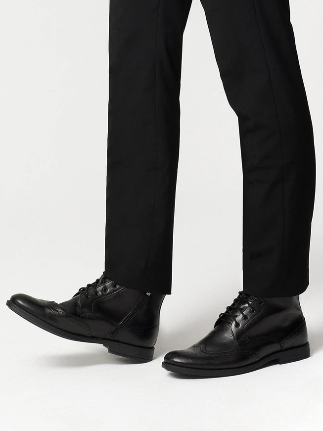 Schwarze Stiefel mit dekorativen Perforationen auf dem Schaft