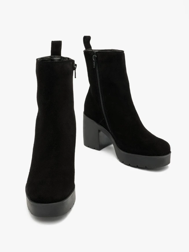 Schwarze Stiefel mit massivem Absatz, isoliert mit natürlichem Schafsfell