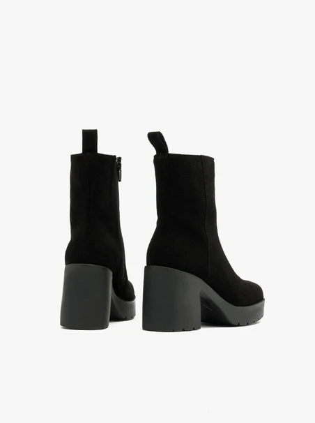 Schwarze Stiefel mit massivem Absatz, isoliert mit natürlichem Schafsfell