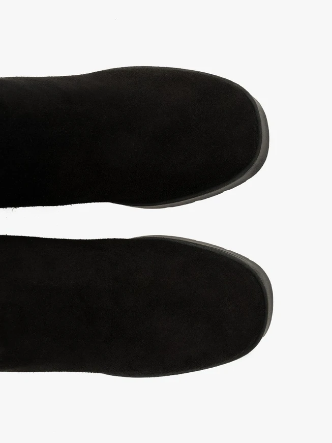 Schwarze Stiefel mit massivem Absatz, isoliert mit natürlichem Schafsfell