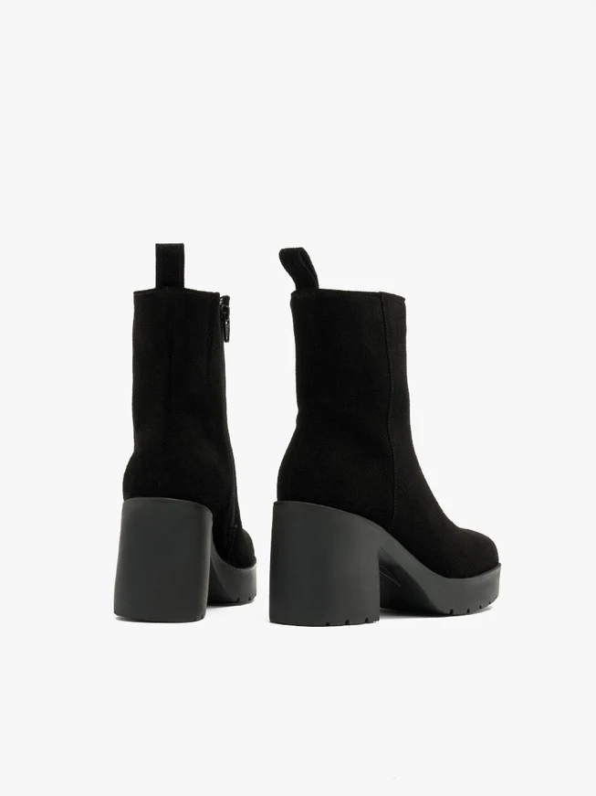 Schwarze Stiefel mit massivem Absatz, isoliert mit natürlichem Schafsfell