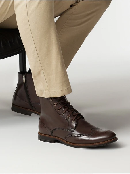 Braune Stiefel mit dekorativen Perforationen auf dem Schaft