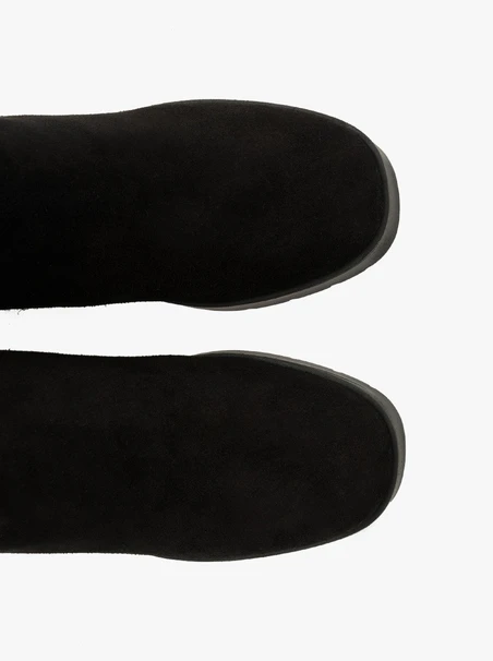 Schwarze Stiefel mit massivem Absatz, isoliert mit natürlichem Schafsfell