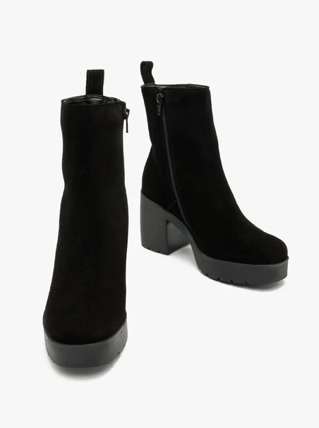 Schwarze Stiefel mit massivem Absatz, isoliert mit natürlichem Schafsfell
