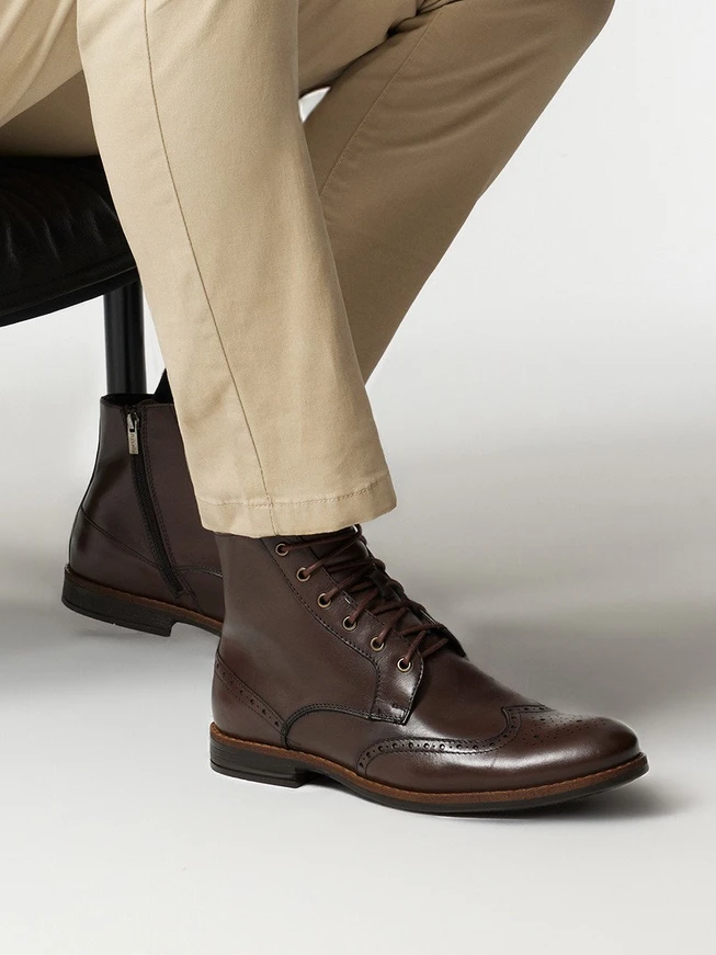 Braune Stiefel mit dekorativen Perforationen auf dem Schaft