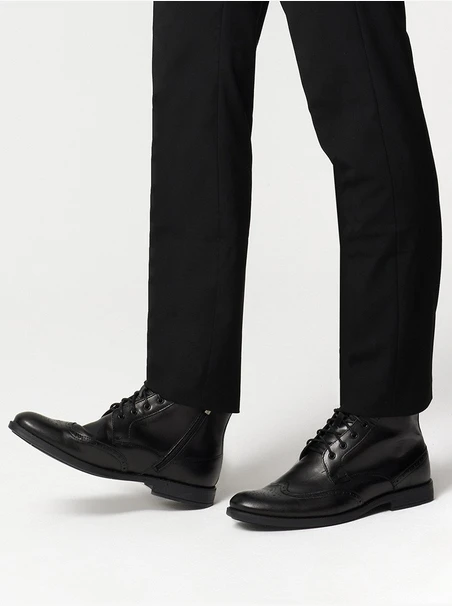 Schwarze Stiefel mit dekorativen Perforationen auf dem Schaft