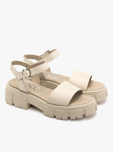 Cremefarbene Sandalen mit silberner Clutch