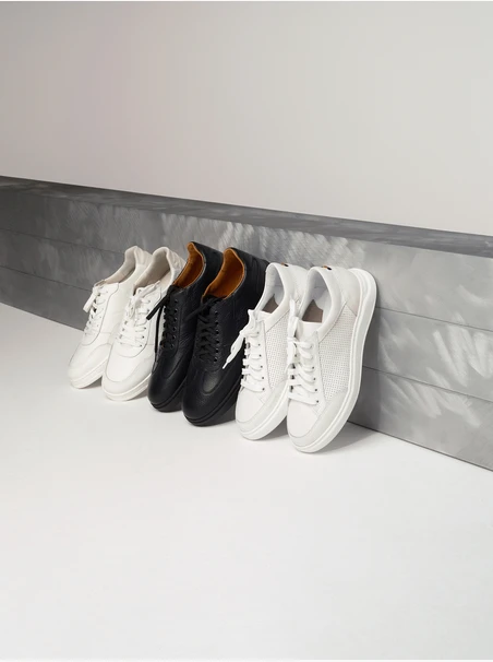 Weiße Herren-Sportschuhe mit dekorativen Perforationen