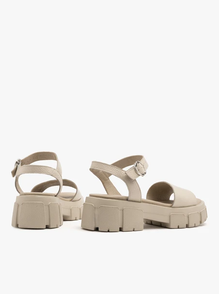 Cremefarbene Sandalen mit silberner Clutch