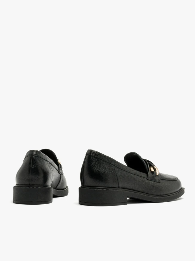 Black loafers with gold-and-black ornament