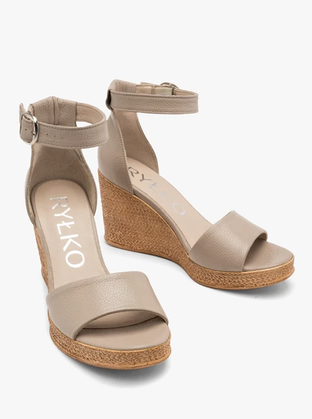 Beigefarbene Sandalen mit Riemen um den Knöchel