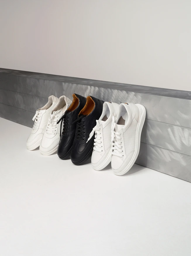 Weiße Herren-Sportschuhe mit dekorativen Perforationen