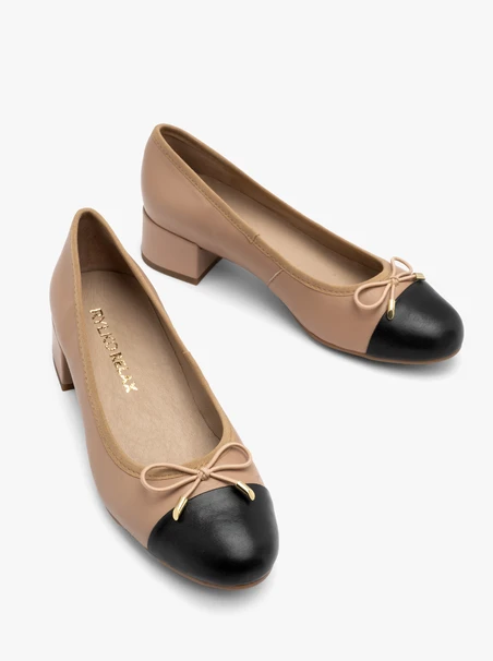 Beige and black pumps with decorative bow