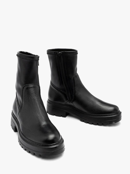 Black stretch ankle boots on a flat sole