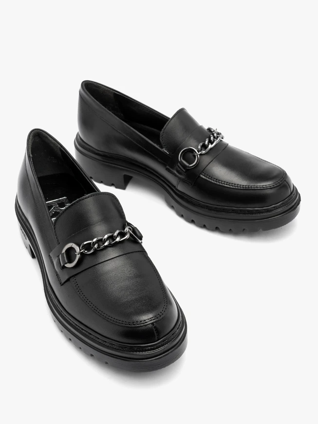 Schwarze Mokassins mit Kette auf dem Schaft