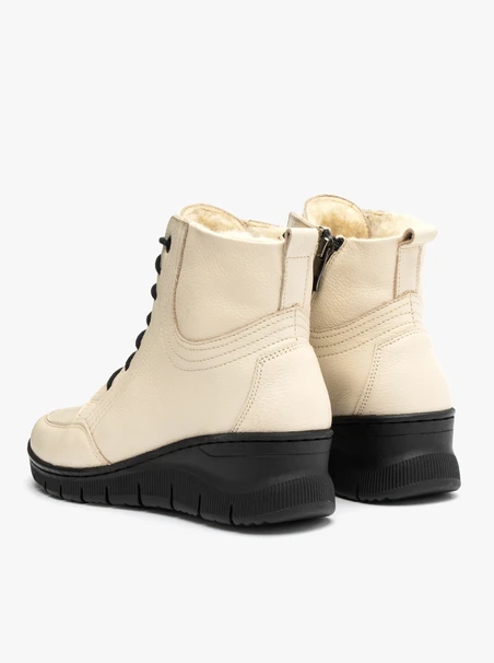 Beigefarbene Stiefel, isoliert mit natürlichem Schafsfell