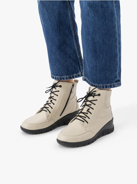 Beigefarbene Stiefel, isoliert mit natürlichem Schafsfell