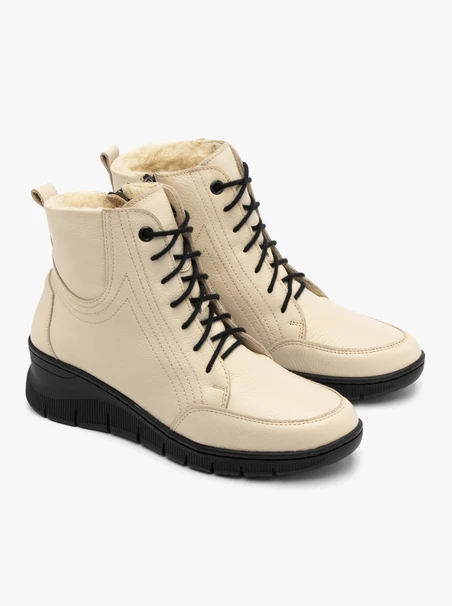 Beigefarbene Stiefel, isoliert mit natürlichem Schafsfell