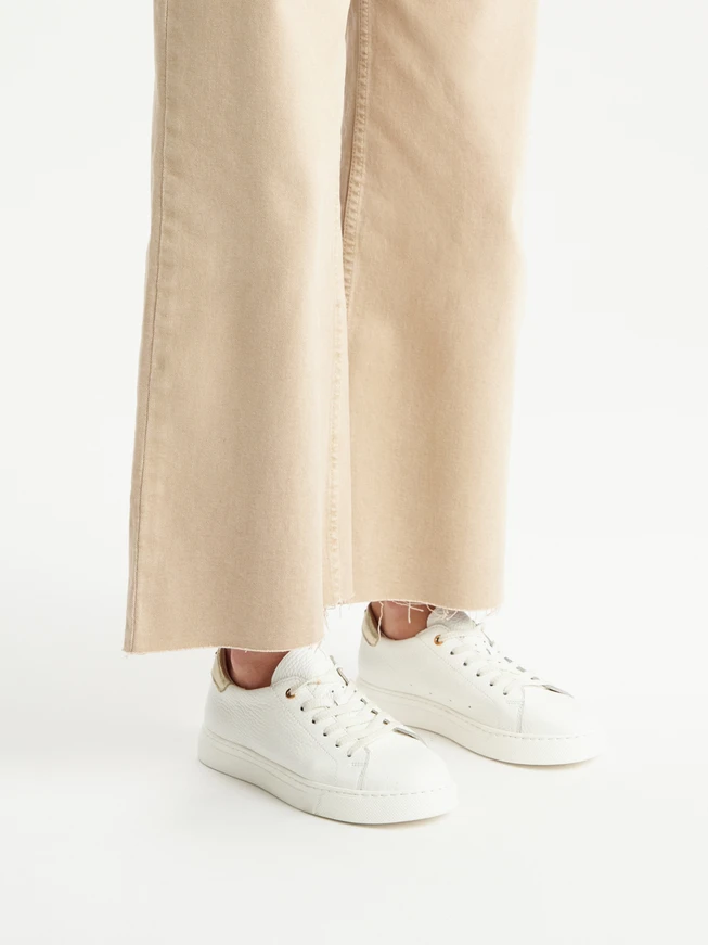 White sporty shoes with a platinum heel tab