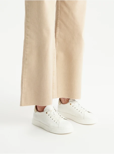 White sporty shoes with a platinum heel tab