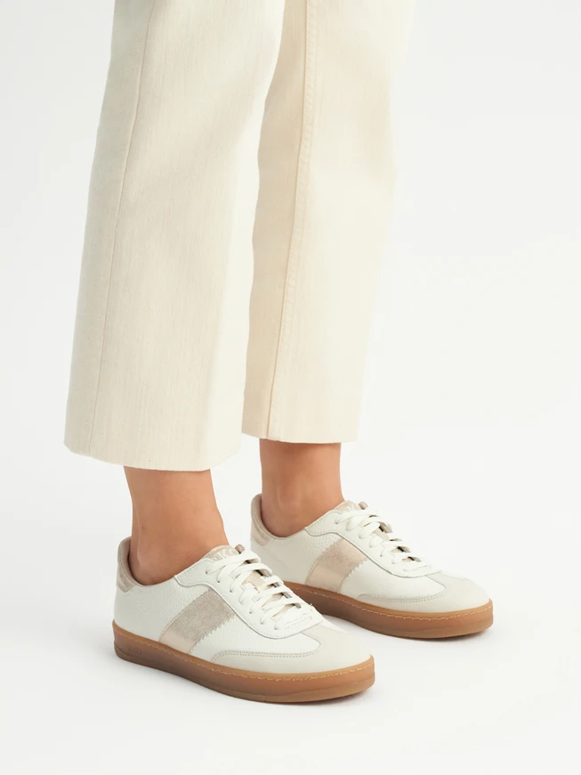 Cremefarbene Sporthalbschuhe mit Platinverzierung
