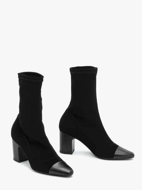 Schwarze höhere Stiefel mit elastischem Schaft auf einem Pfosten