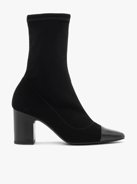 Schwarze höhere Stiefel mit elastischem Schaft auf einem Pfosten