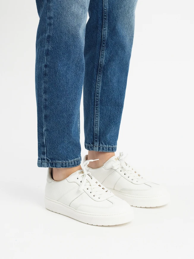 Weiße Sportschuhe auf leichtem Boden