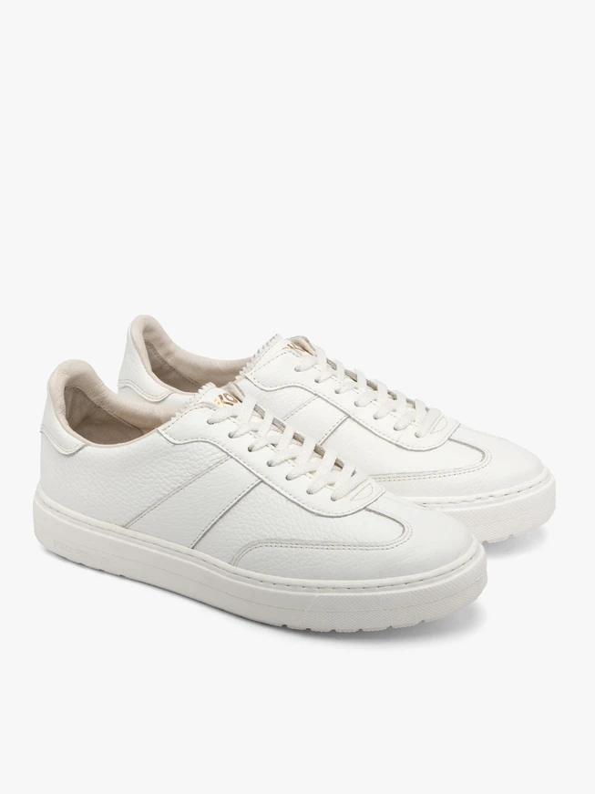 Weiße Sportschuhe auf leichtem Boden