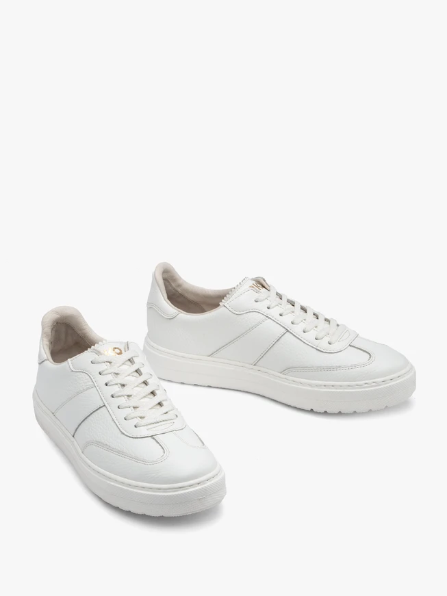 Weiße Sportschuhe auf leichtem Boden
