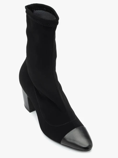 Schwarze höhere Stiefel mit elastischem Schaft auf einem Pfosten