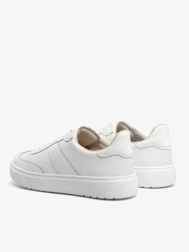 Weiße Sportschuhe auf leichtem Boden