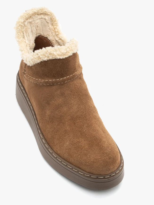 Rote Schneestiefel mit Fell auf einem dickeren Boden