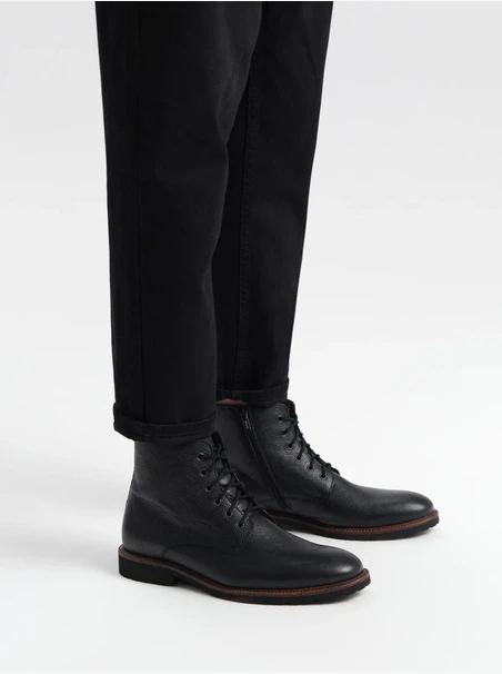 Schwarzer Herrensneaker mit dekorativer Ottomane an der Unterseite