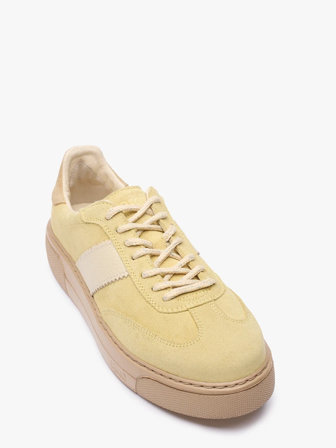 Leuchtend gelbe Turnschuhe aus Leder und Velours